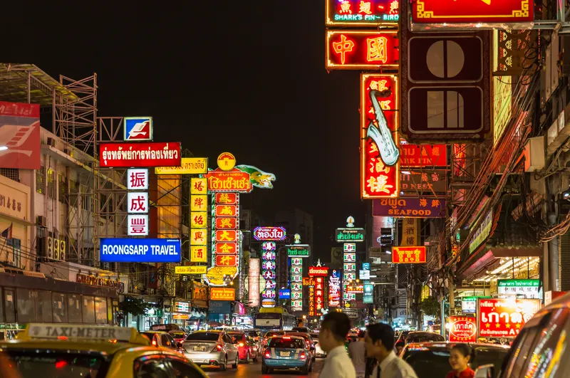 Neon signs and food stalls along Yaowarat Road at night in Bangkok Chinatown