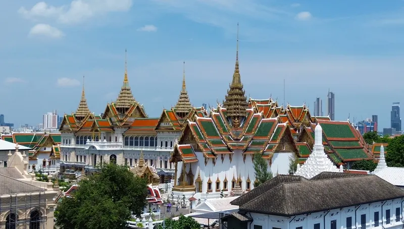 Grand Palace rooftops and Bangkok skyline beside the Chao Phraya River