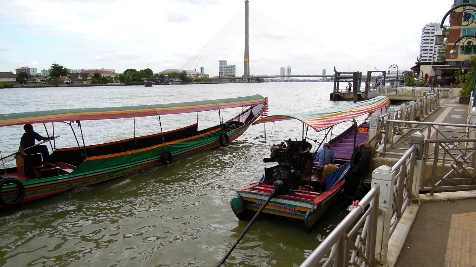Long-tail boats and ferries moving along the Chao Phraya River